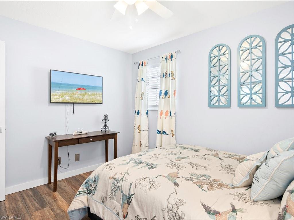 Bedroom with dark wood-style flooring and a ceiling fan