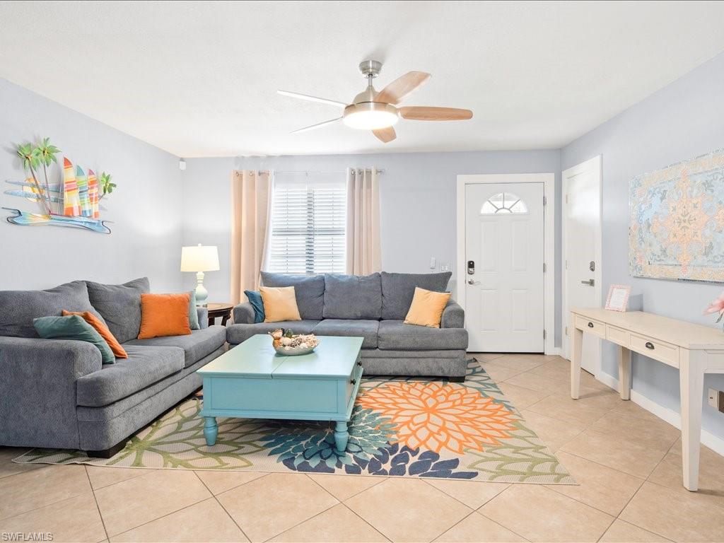Living room with light tile patterned floors and ceiling fan