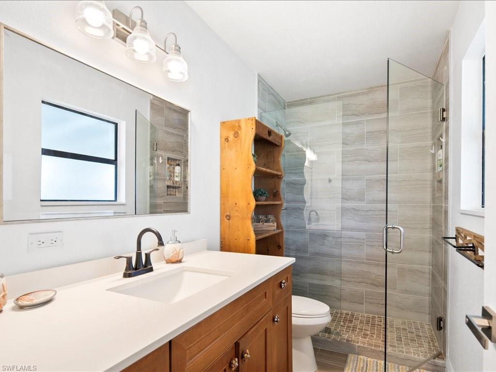 Bathroom with plenty of natural light, vanity, and a shower stall