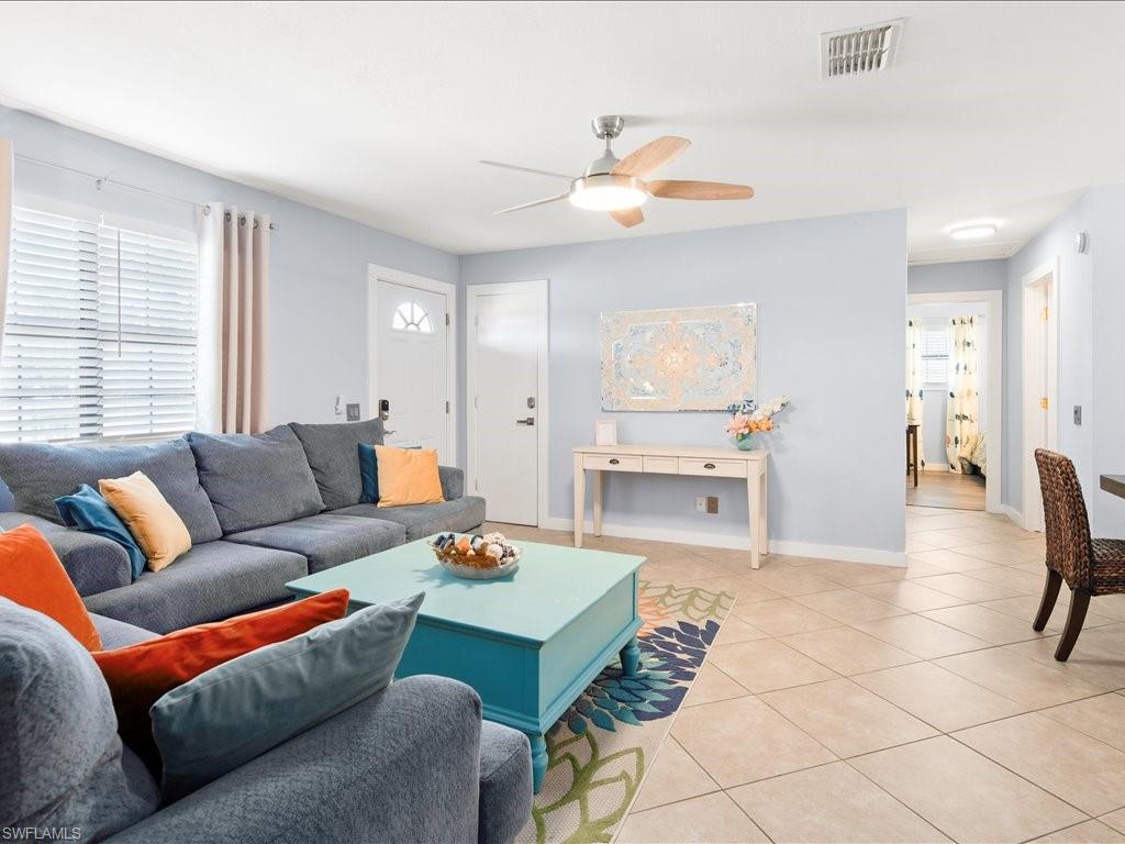 Living area featuring tile patterned flooring and ceiling fan