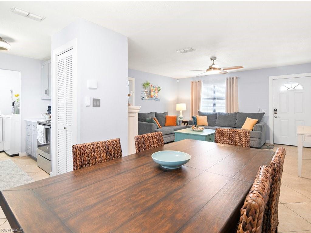 Dining room featuring light tile patterned floors, ceiling fan, and washing machine and clothes dryer