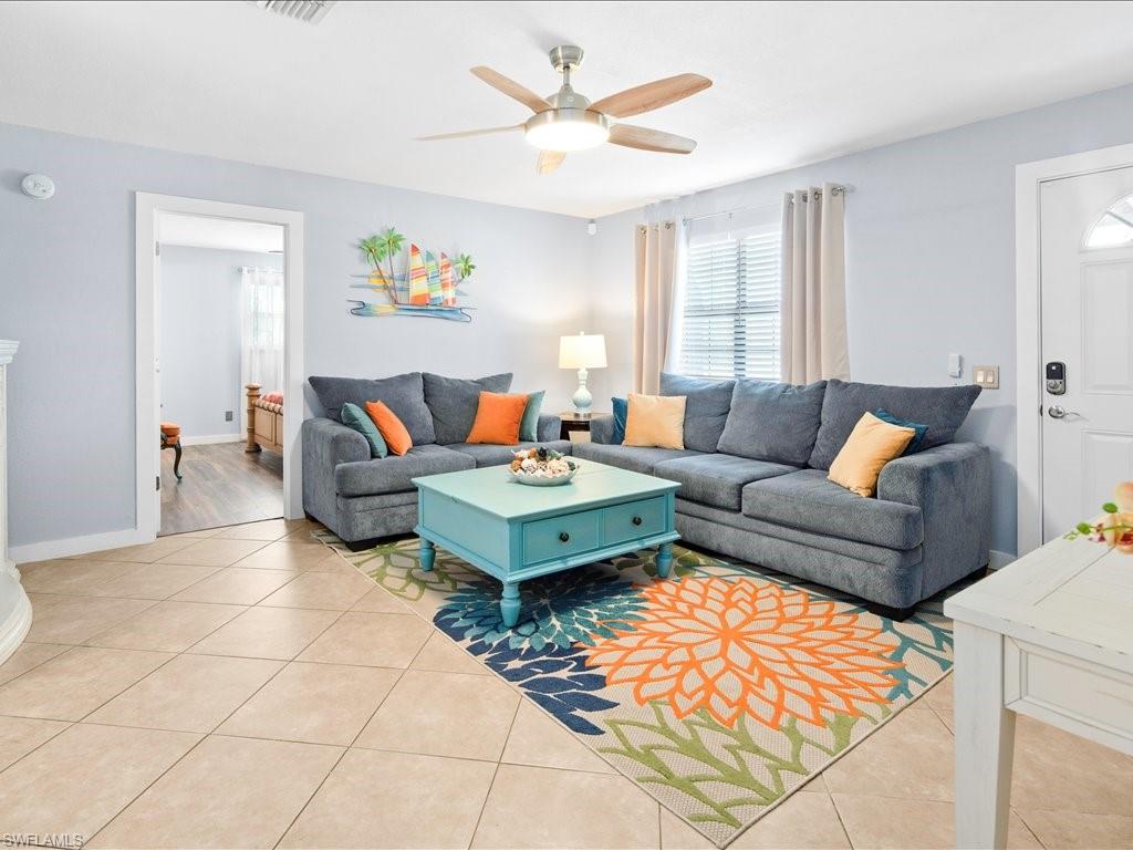 Living area with light tile patterned floors and ceiling fan
