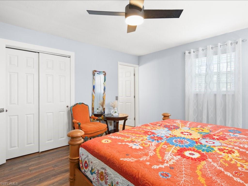 Bedroom featuring dark wood-type flooring, a ceiling fan, and a closet