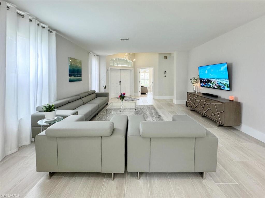 Living room featuring light wood-style floors and a chandelier