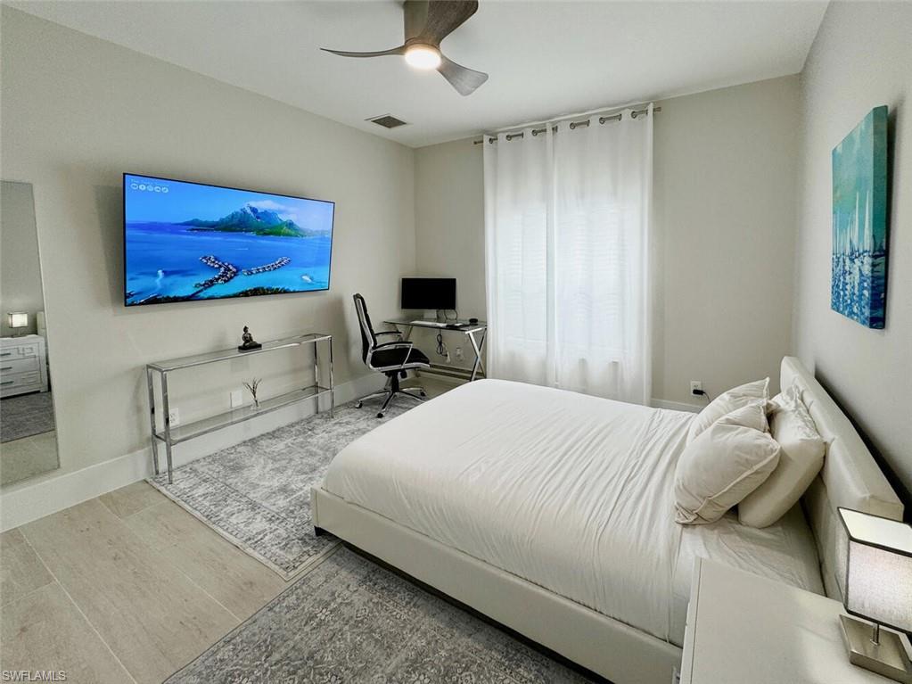 Bedroom with an office area, wood finished floors, and ceiling fan