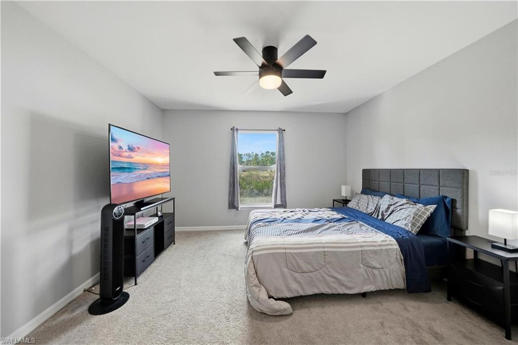 Bedroom featuring light colored carpet and a ceiling fan