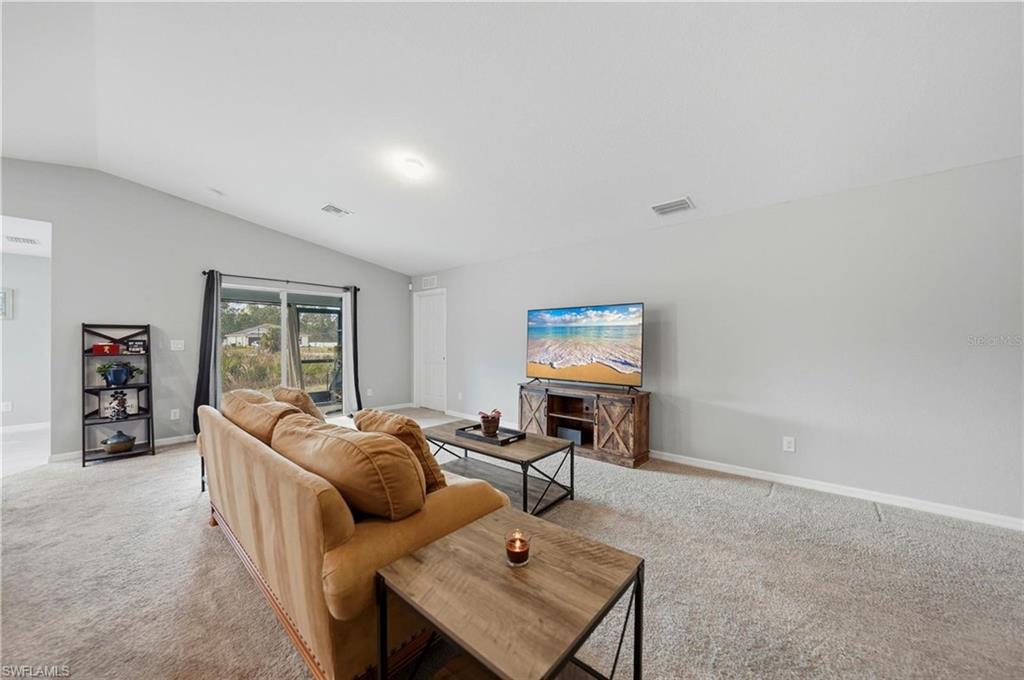 Living room featuring light carpet and vaulted ceiling