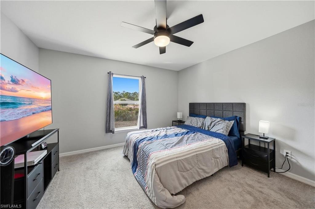 Bedroom featuring light colored carpet and ceiling fan