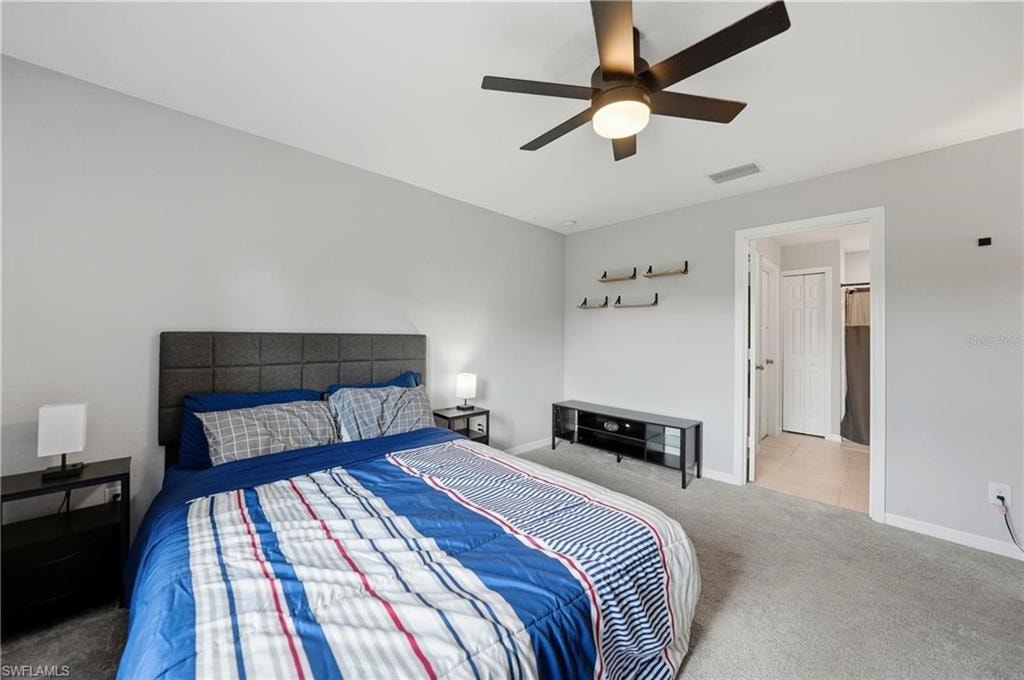 Carpeted bedroom with baseboards and a ceiling fan