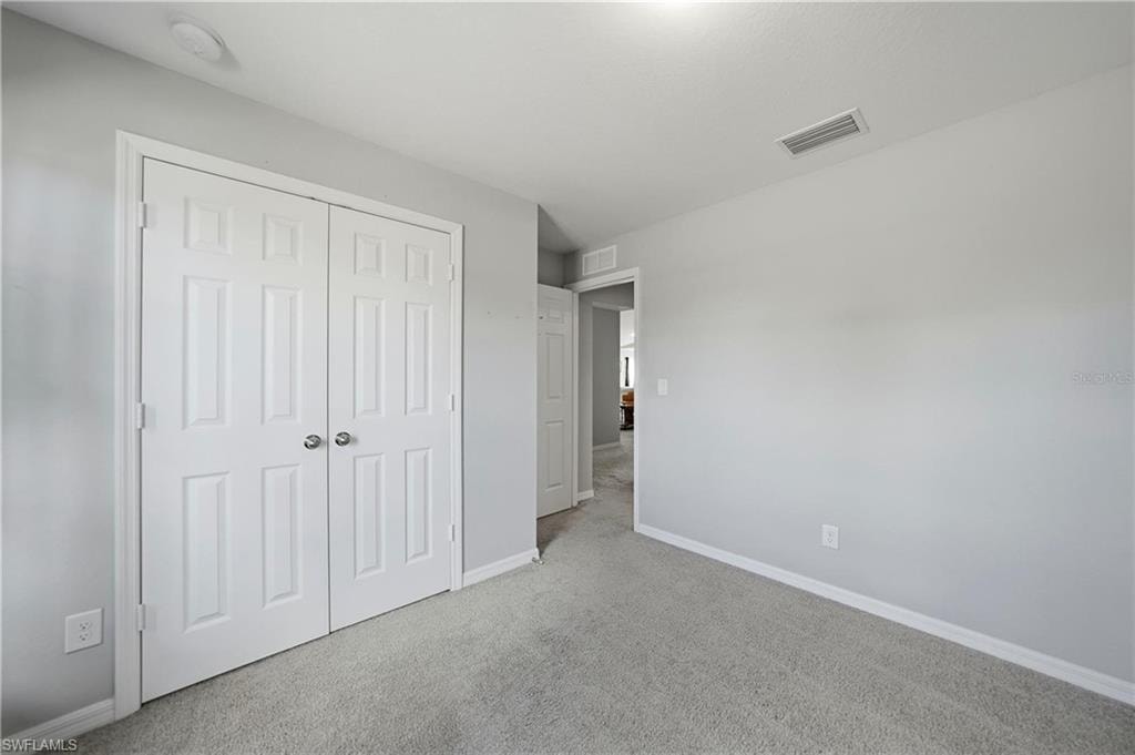 Unfurnished bedroom with carpet and a closet