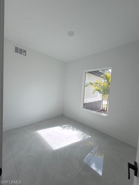 Empty room featuring a raised ceiling and ceiling fan
