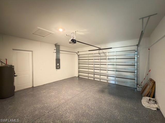 Garage featuring water heater and a garage door opener