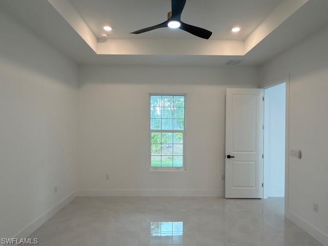 Spare room featuring a tray ceiling, ceiling fan, and recessed lighting