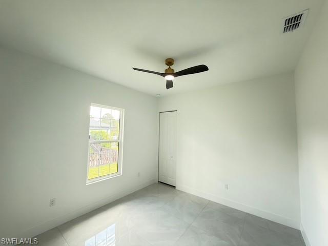 Empty room featuring baseboards and ceiling fan