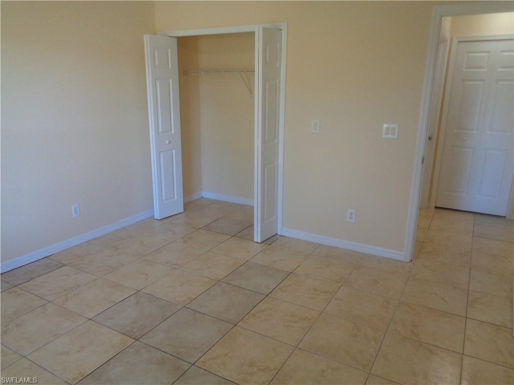 Guest bedroom 1 with a closet and light tile patterned flooring