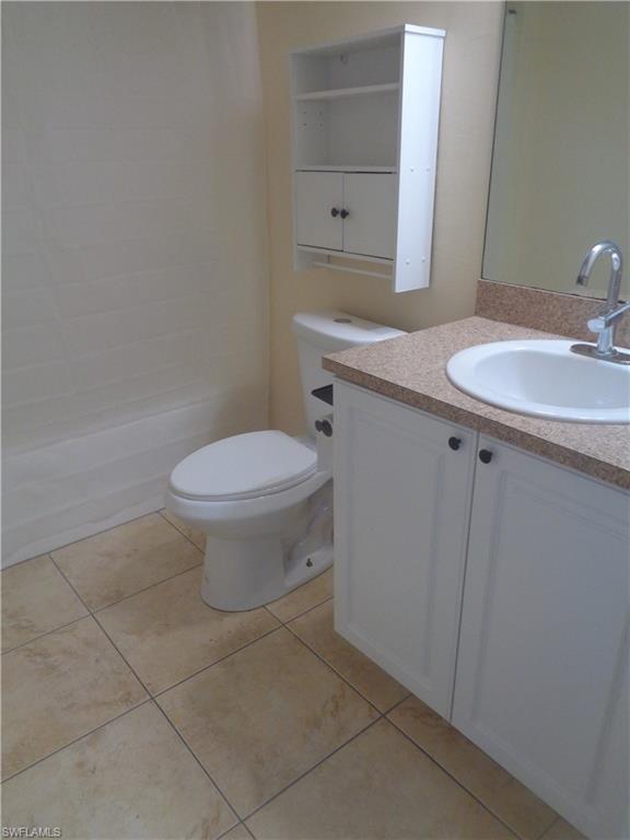 Guest bathroom with vanity, toilet, shower / tub and light tile patterned flooring