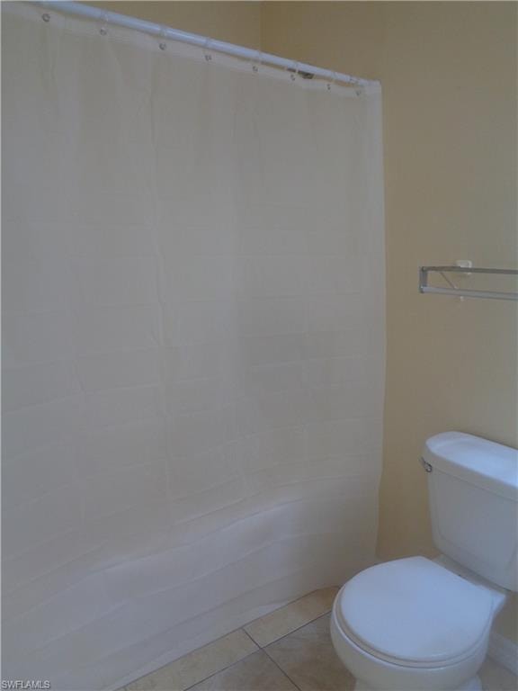 Master bedroom's bathroom featuring shower / tub, toilet and light tile patterned flooring