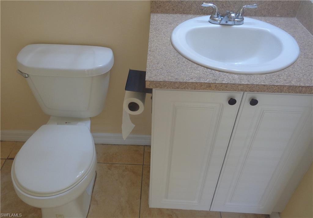 Master bedroom's bathroom featuring vanity and toilet and light tile patterned flooring