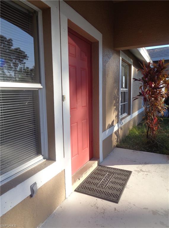 View of exterior entry featuring porch stucco siding