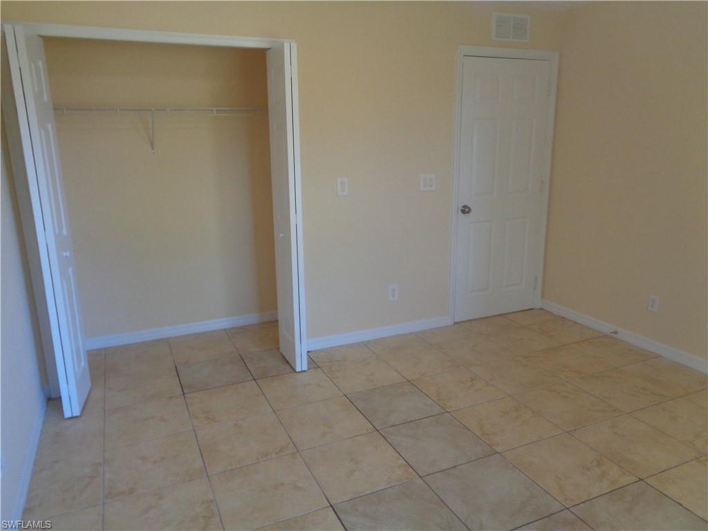 Guest bedroom 1 with a closet and light tile patterned flooring