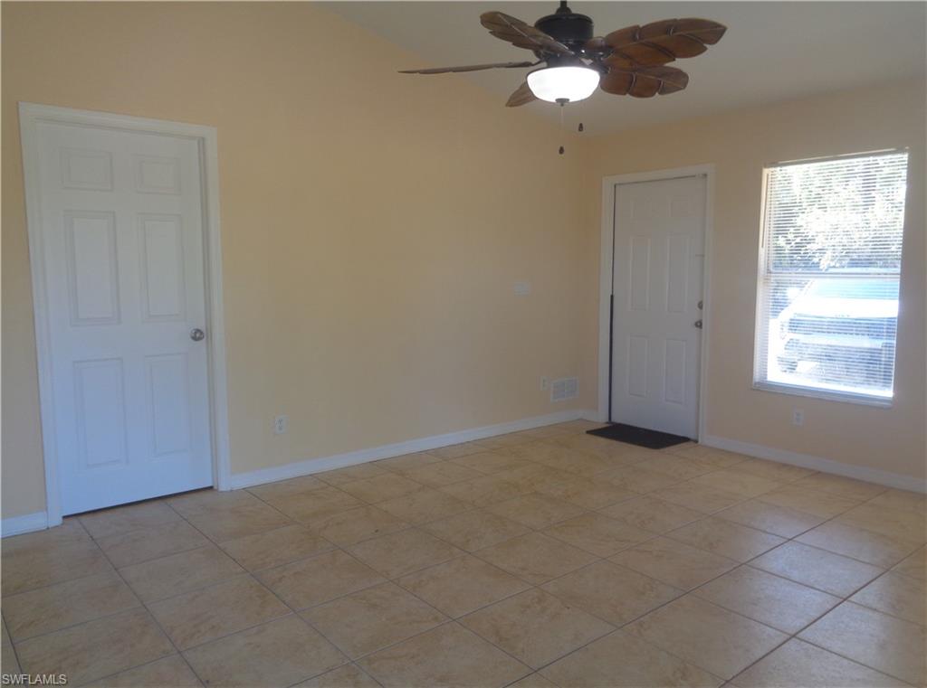Living room with light tile patterned floors and ceiling fan
