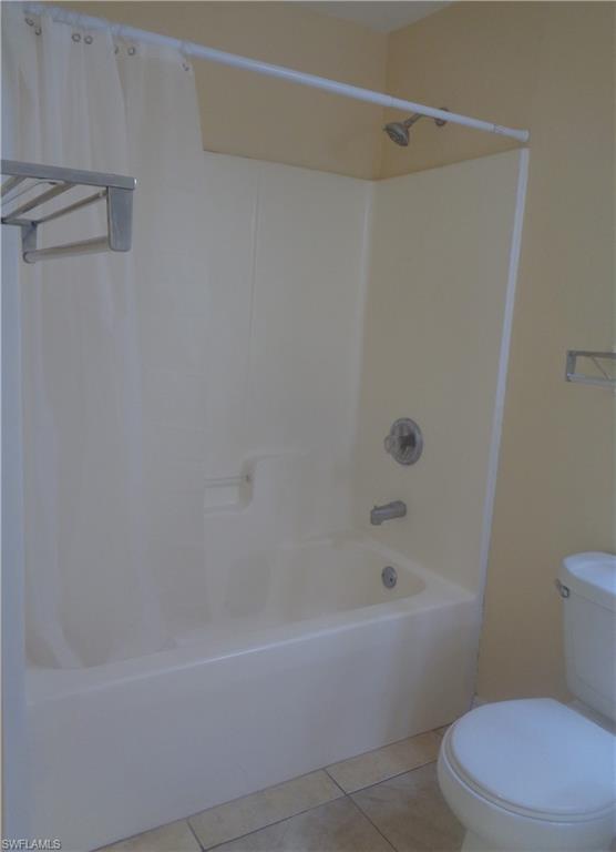 Master bedroom's bathroom featuring shower / tub and toilet and light tile patterned flooring