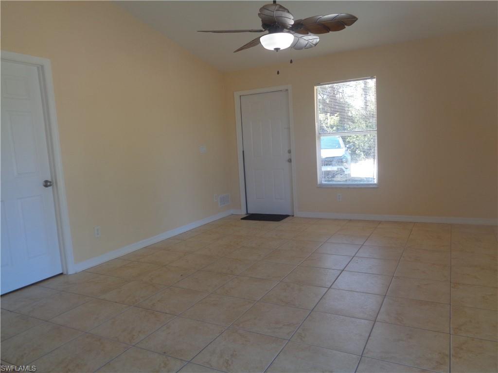 Living room with light tile patterned flooring and ceiling fan