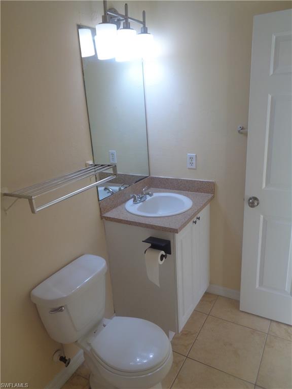 Master bathroom with vanity, toilet and light tile patterned floors