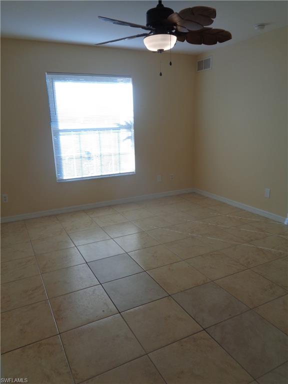Master bedroom with light tile patterned floors and ceiling fan