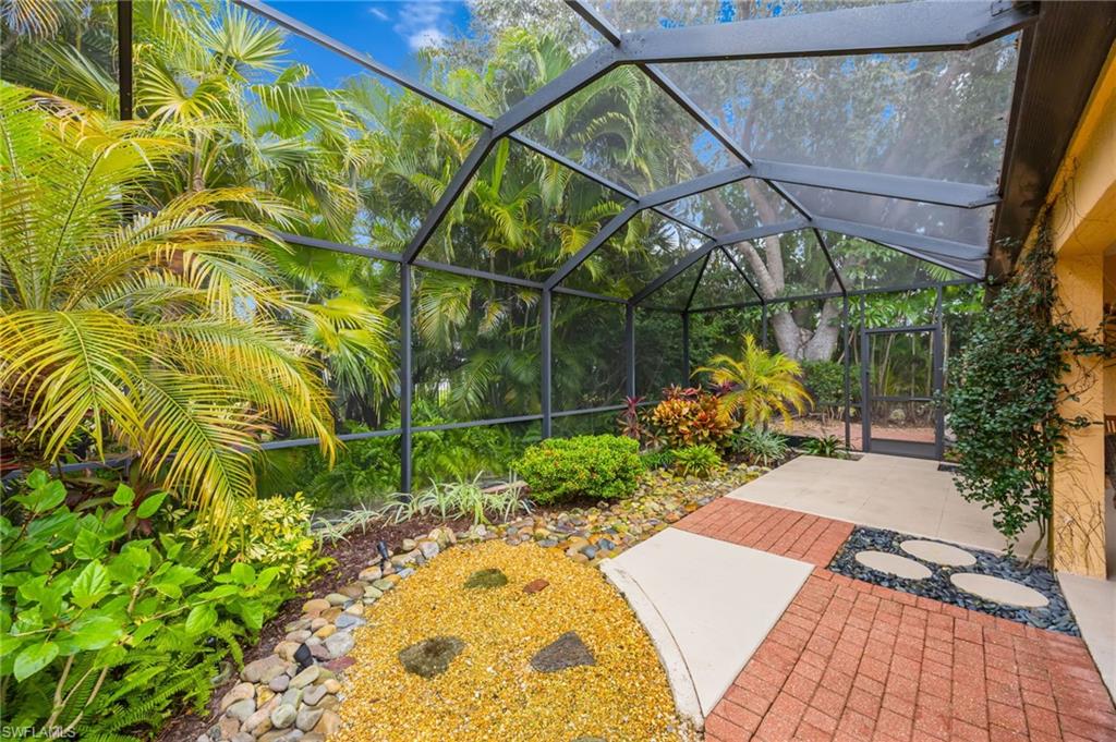 View of screened in lanai, featuring mature landscaping