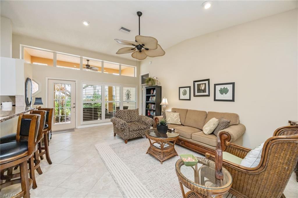 Living room with recessed lighting, tile patterned floors, a towering ceiling, and ceiling fan, couch can be made into a queen sized bed