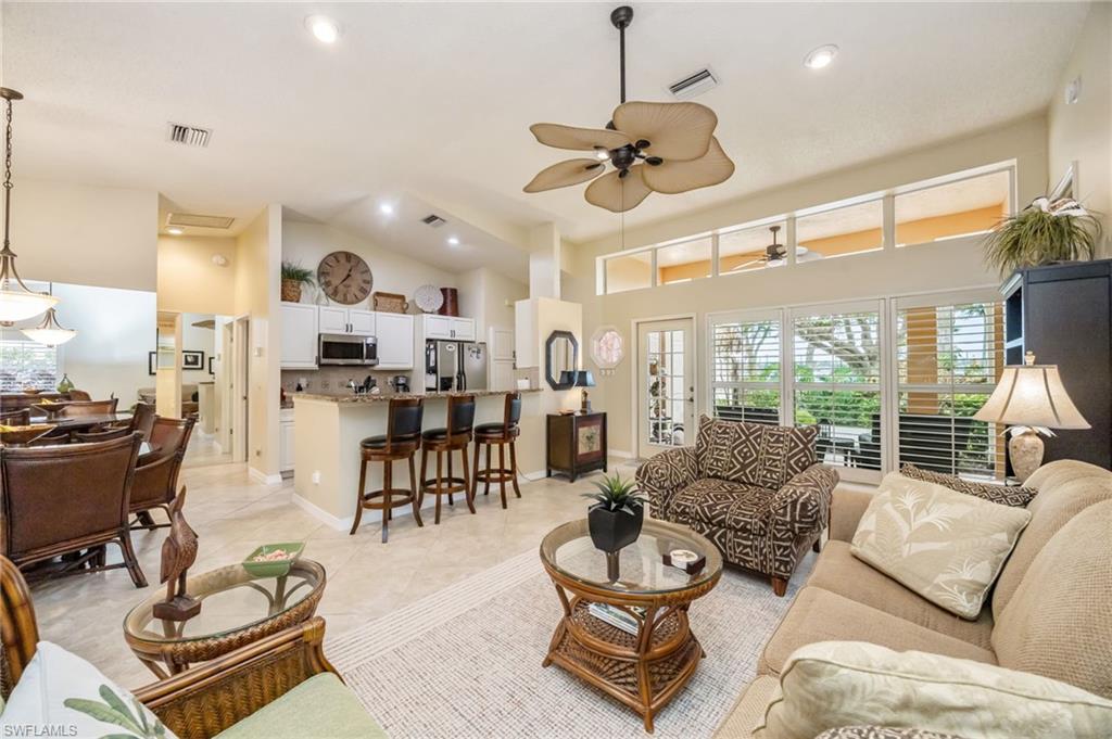 Living area featuring high vaulted ceiling, ceiling fan, recessed lighting, and light tile patterned flooring, couch can be made into a queen sized bed
