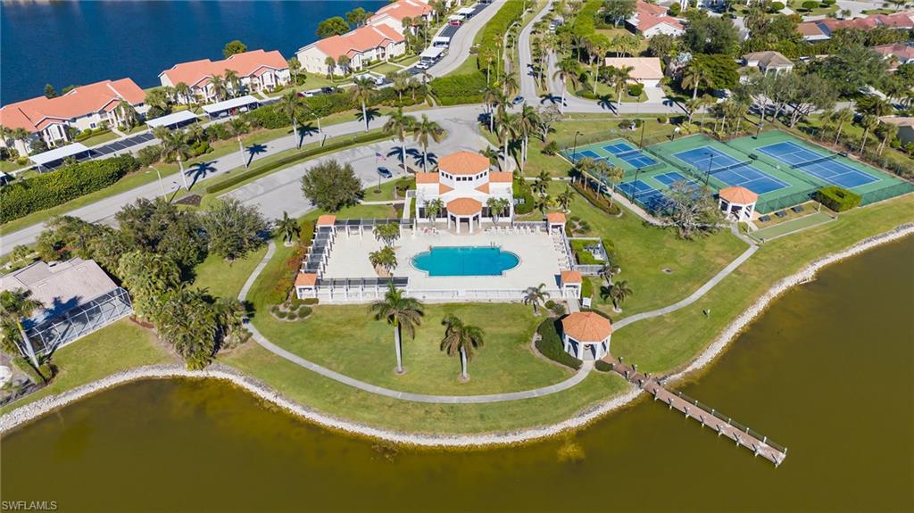 Aerial view of property and surrounding area featuring a nearby body of water and a pool area