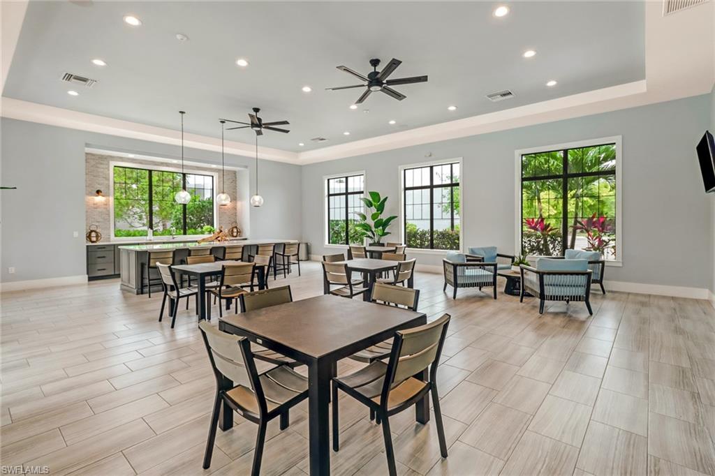 Dining area with a tray ceiling, wood tiled floors, a ceiling fan, and recessed lighting