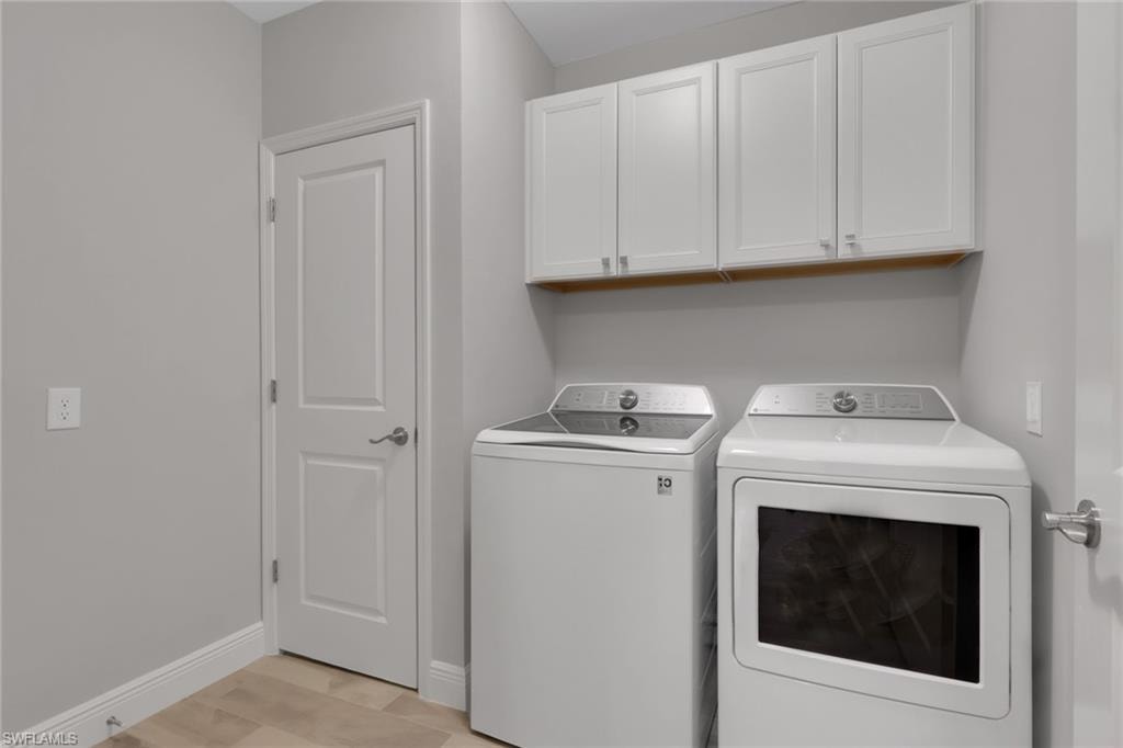 Laundry area featuring washing machine and dryer and cabinet space