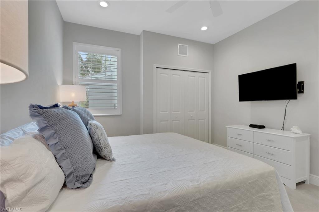 Bedroom with a closet, a ceiling fan, recessed lighting, and light colored carpet