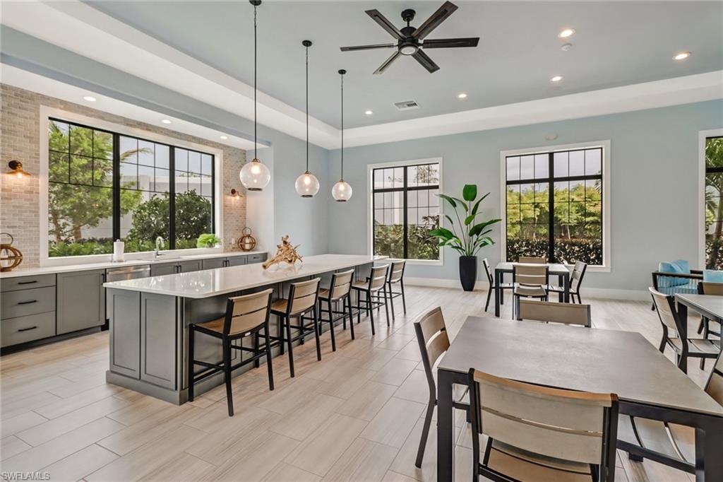 Dining area with recessed lighting, ceiling fan, and a tray ceiling