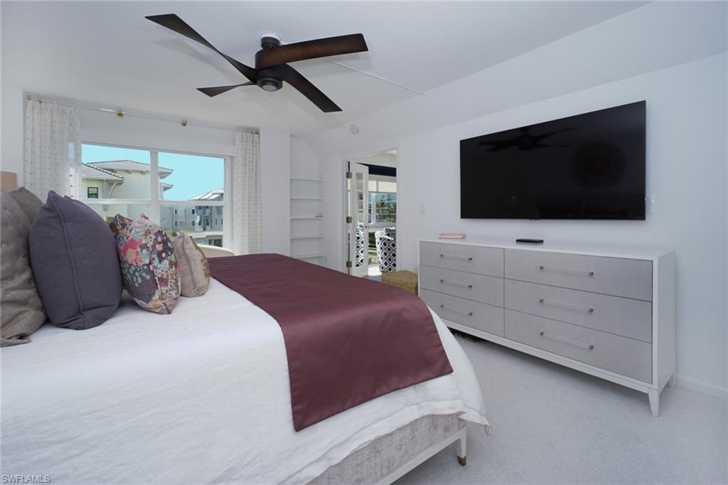 Bedroom featuring light carpet, multiple windows, and a ceiling fan