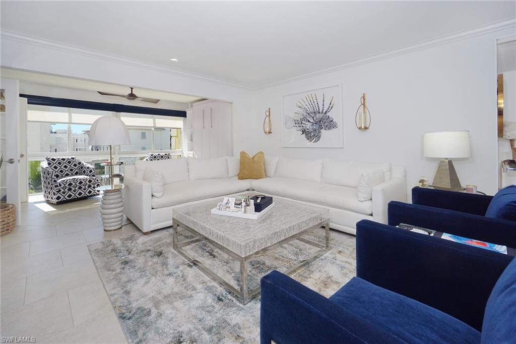 Tiled living room with crown molding and a ceiling fan