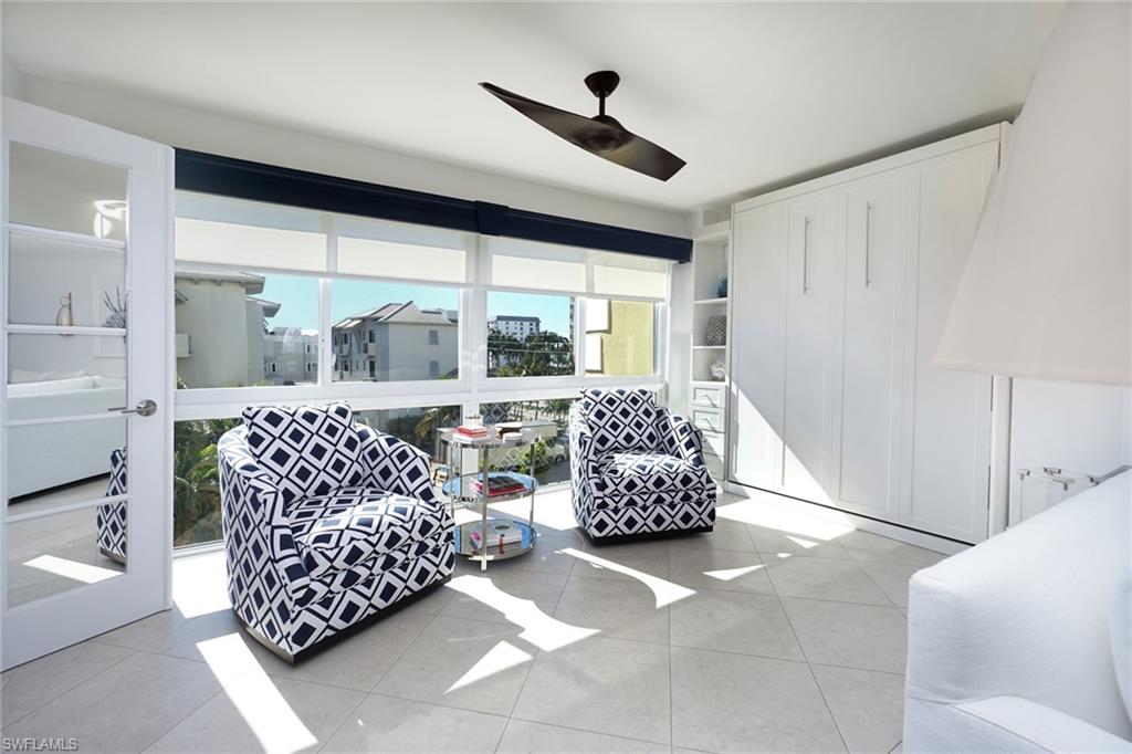 Living area featuring light tile patterned flooring and ceiling fan