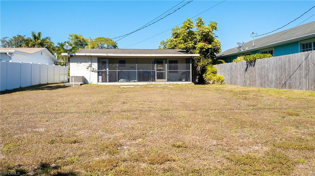 Back of property with a fenced backyard and a sunroom