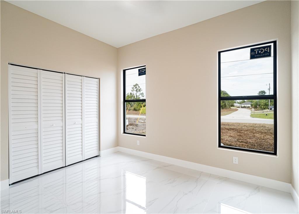 Unfurnished bedroom featuring light marble finish flooring and a closet