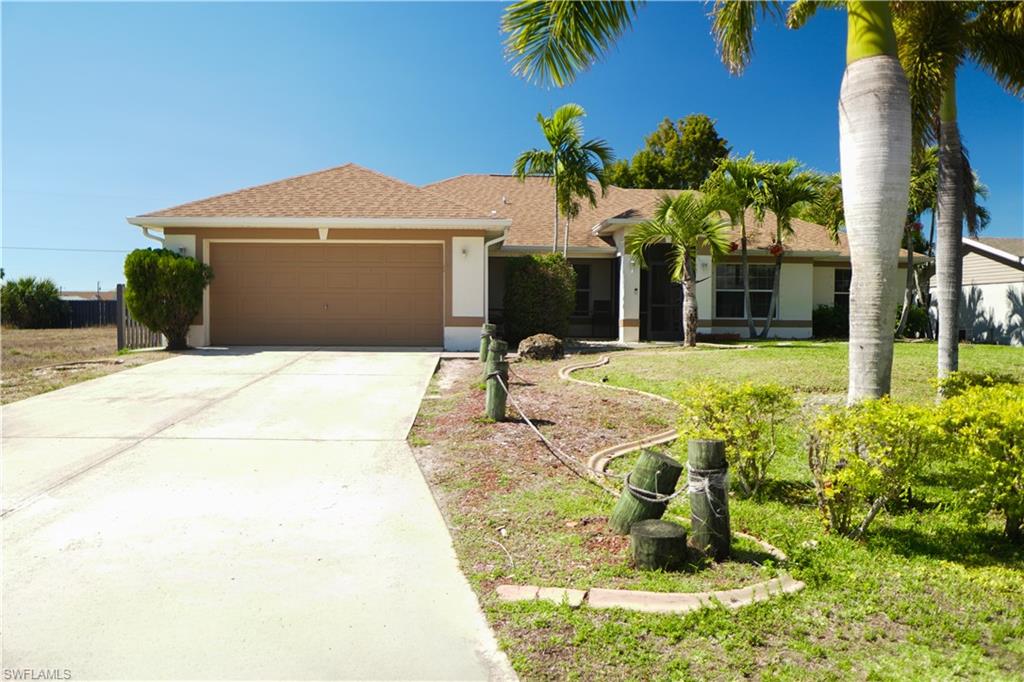 Single story home featuring an attached garage, concrete driveway, stucco siding, roof with shingles, and a front yard