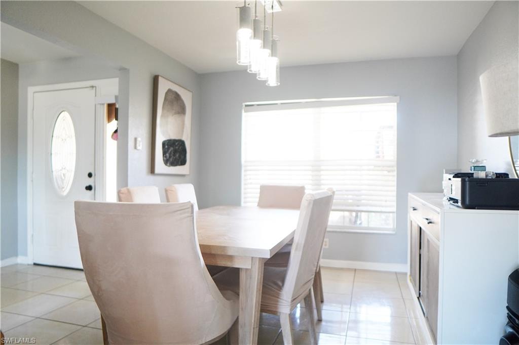 Dining room featuring light tile patterned floors and baseboards