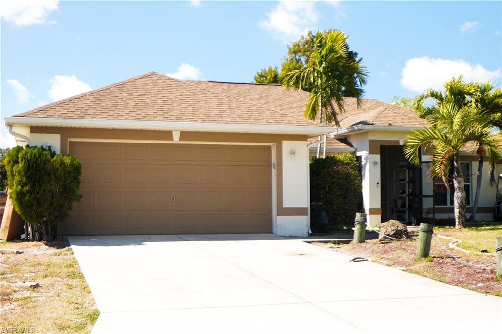 Ranch-style home featuring a garage, a shingled roof, stucco siding, and concrete driveway