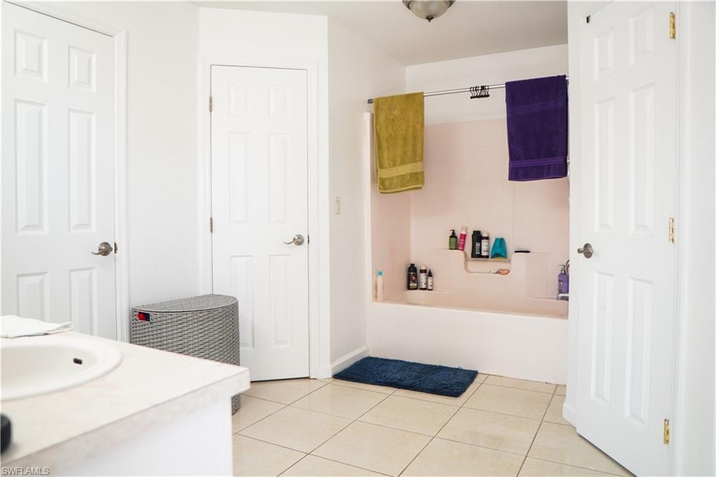 Full bathroom with vanity, light tile patterned flooring, and shower / bathtub combination