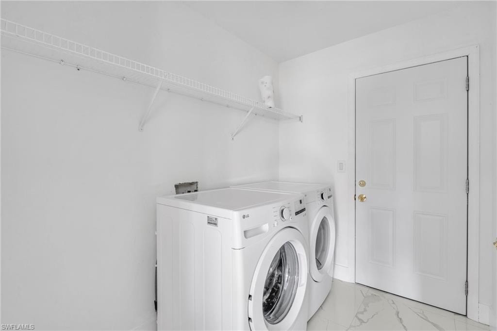 Laundry room featuring washer and dryer and marble finish floors