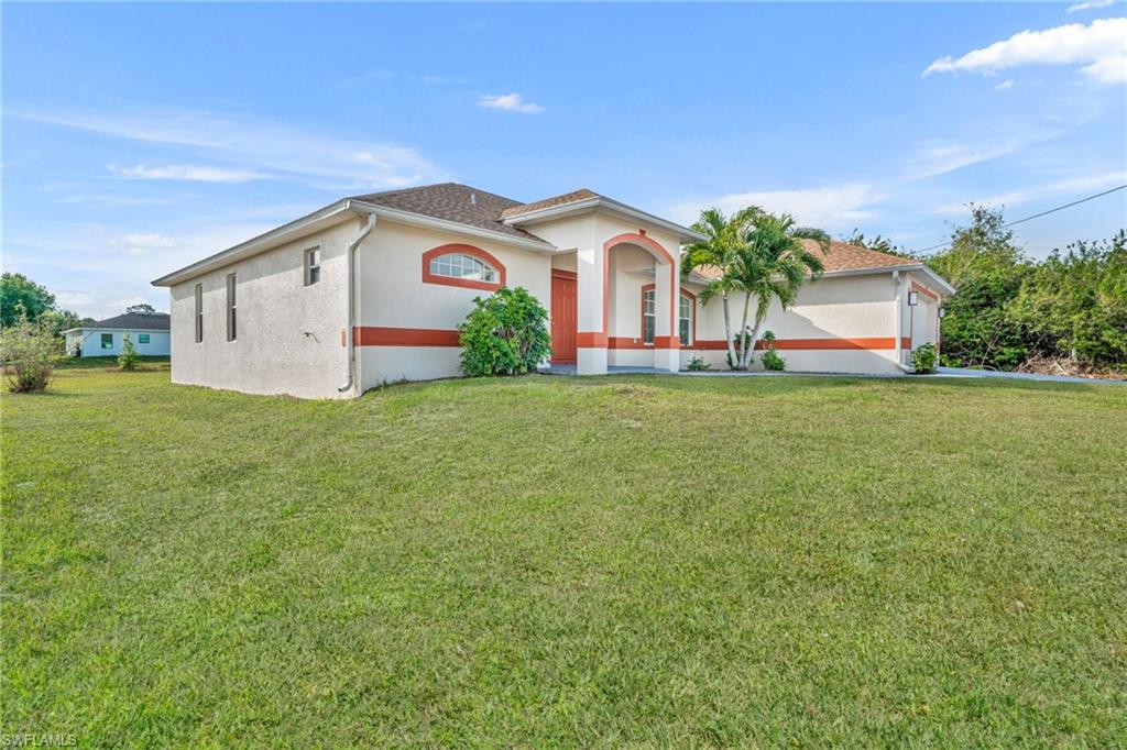 Mediterranean / spanish-style house with stucco siding and a front yard