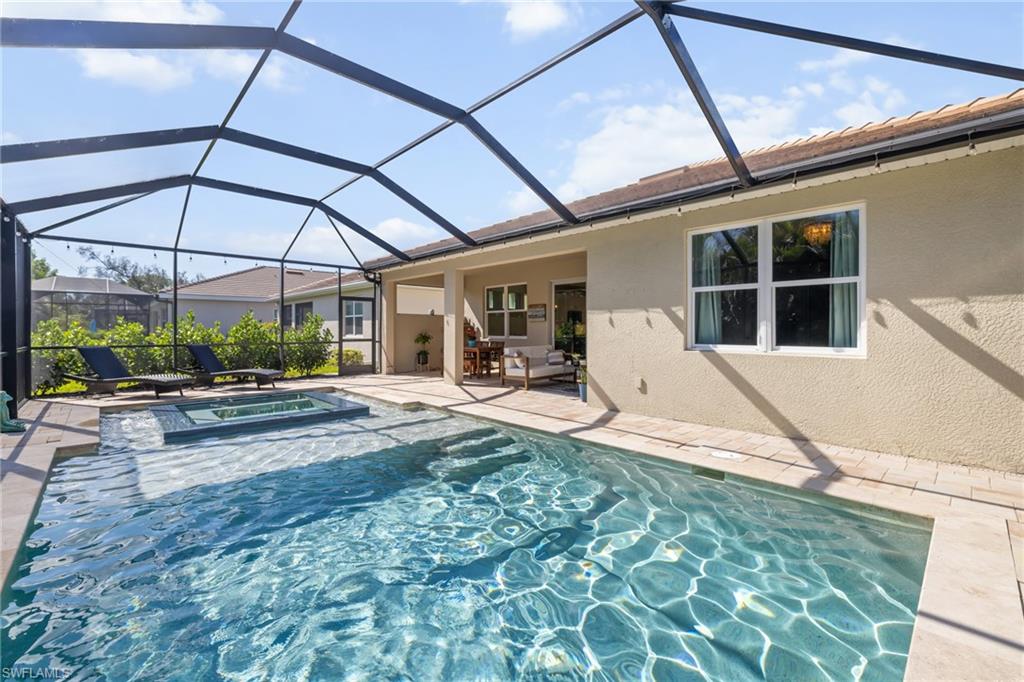 View of swimming pool with a sunroom, a patio area, a lanai, and a pool with connected hot tub