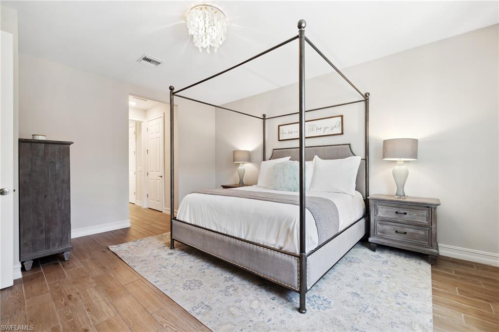Bedroom featuring wood finish floors and a chandelier